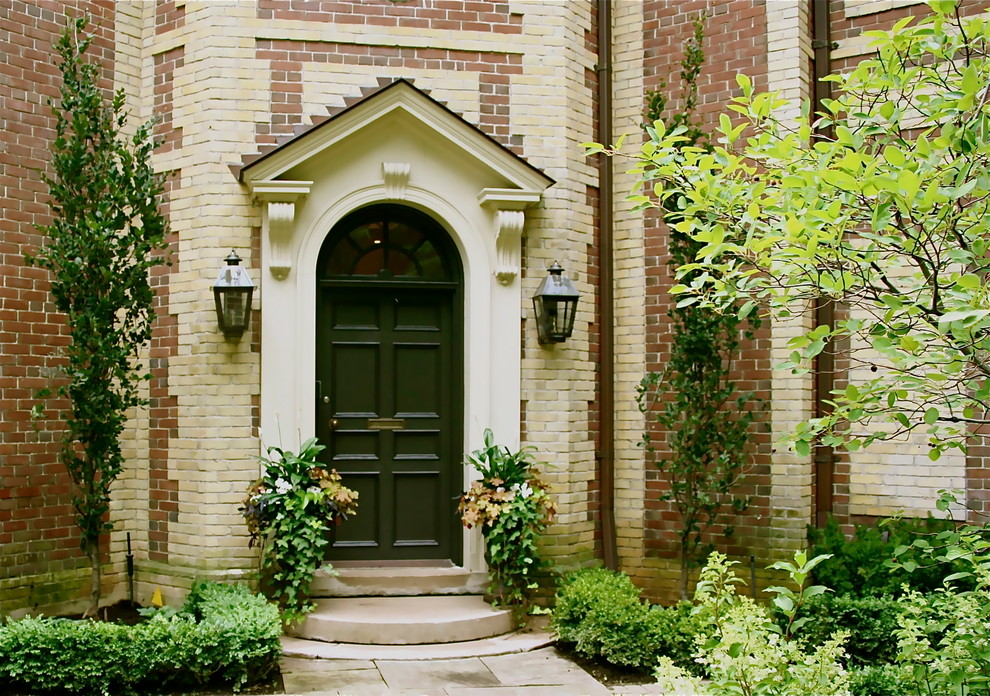 Стильный дизайн: входная дверь среднего размера в классическом стиле с черной входной дверью, красными стенами, бетонным полом и одностворчатой входной дверью - последний тренд