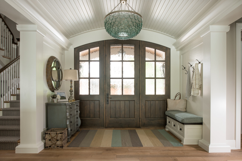 Esempio di un ingresso classico con pareti bianche, pavimento in legno massello medio, una porta singola, una porta in legno bruno e pavimento marrone