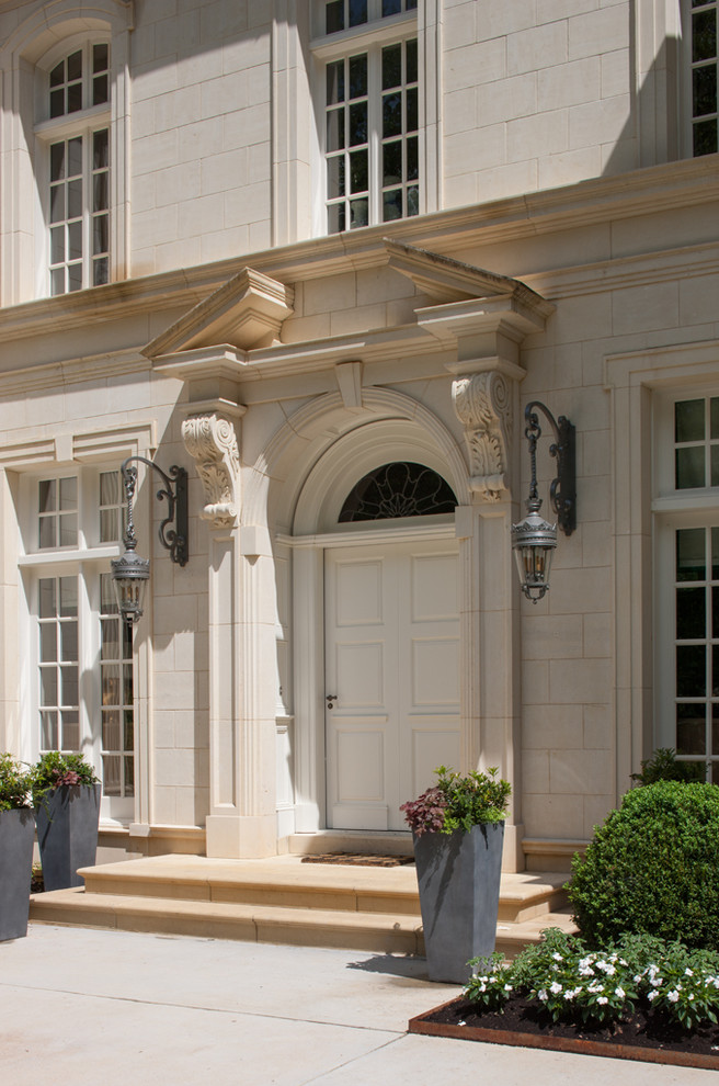 Large elegant limestone floor entryway photo in Atlanta with a white front door and white walls