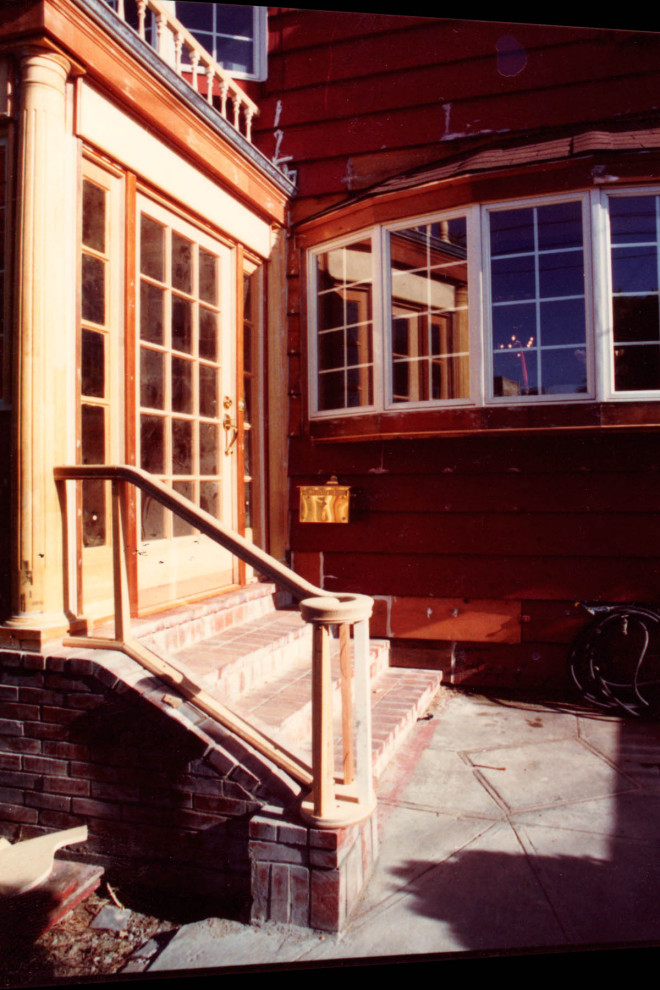 Cette photo montre un vestibule chic de taille moyenne avec un sol en brique, une porte simple, une porte blanche et un sol rouge.