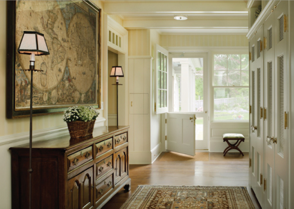 На фото: тамбур среднего размера в классическом стиле с разноцветными стенами, паркетным полом среднего тона, голландской входной дверью, белой входной дверью и коричневым полом