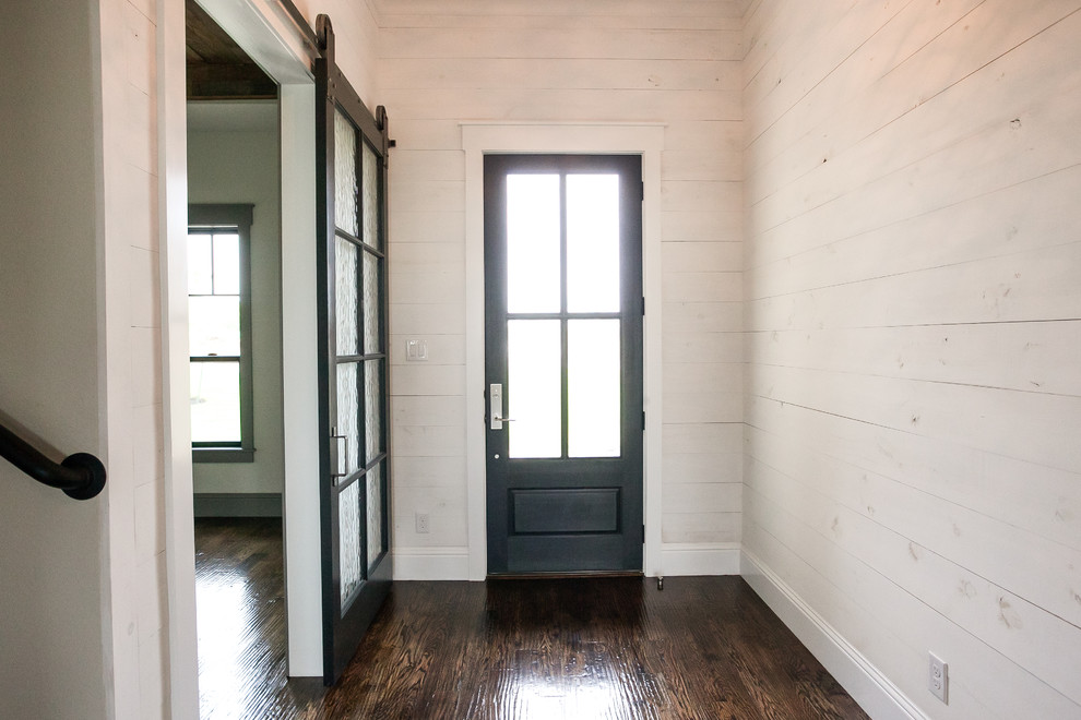 Пример оригинального дизайна: входная дверь среднего размера в стиле кантри с белыми стенами, темным паркетным полом, одностворчатой входной дверью, черной входной дверью и коричневым полом