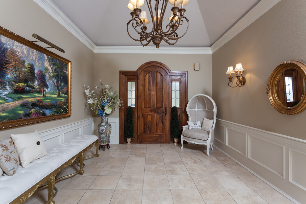 Imagen de hall clásico grande con paredes beige, suelo de baldosas de cerámica, puerta simple, puerta de madera en tonos medios y suelo beige
