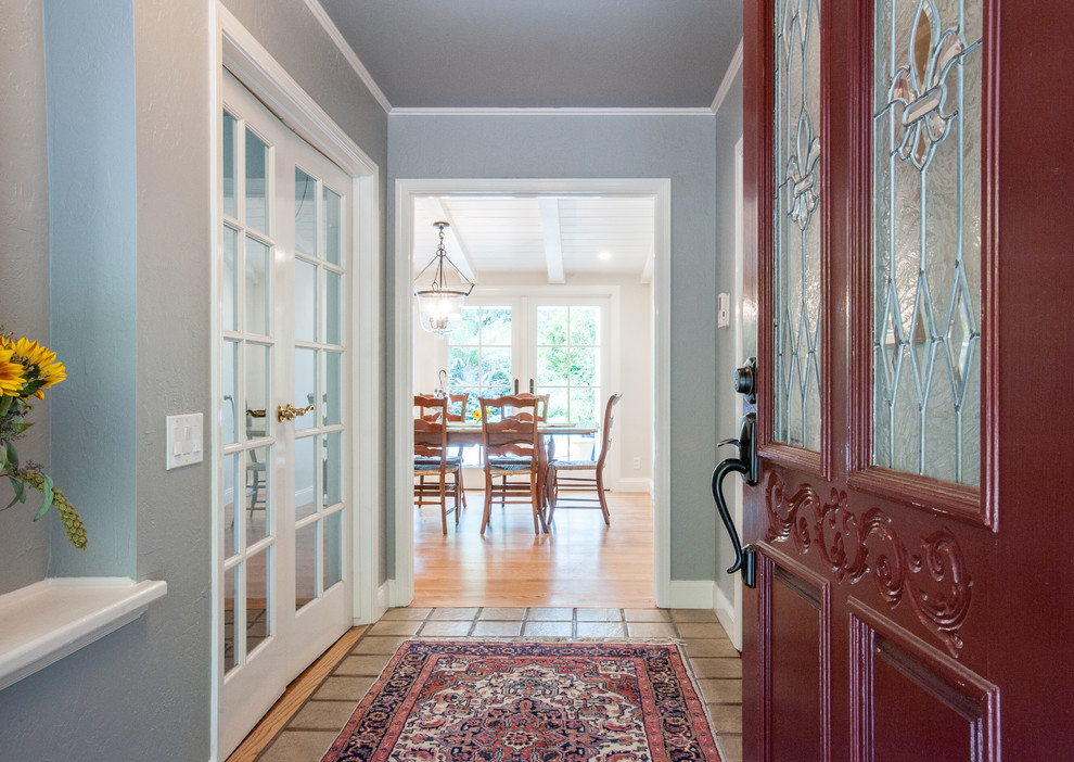 Пример оригинального дизайна: прихожая в классическом стиле с серыми стенами, одностворчатой входной дверью и красной входной дверью