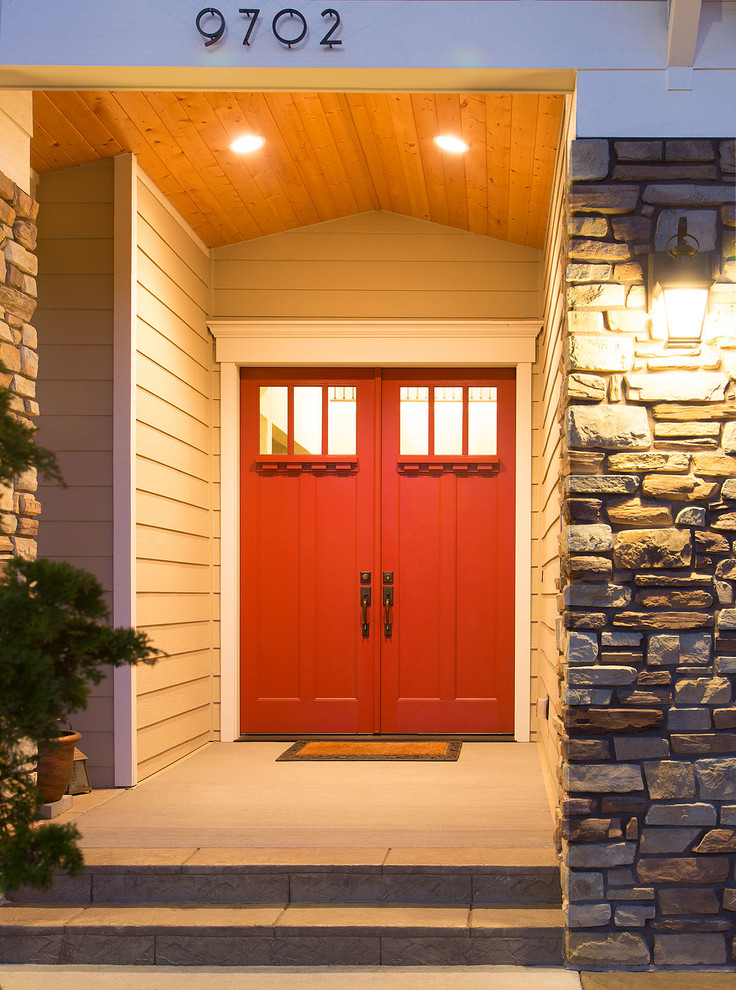 Esempio di una porta d'ingresso classica di medie dimensioni con pareti beige, pavimento in cemento, una porta a due ante e una porta rossa