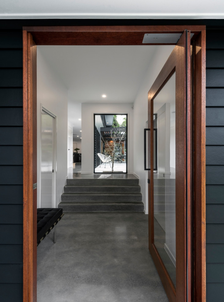 Entryway - contemporary concrete floor entryway idea with black walls