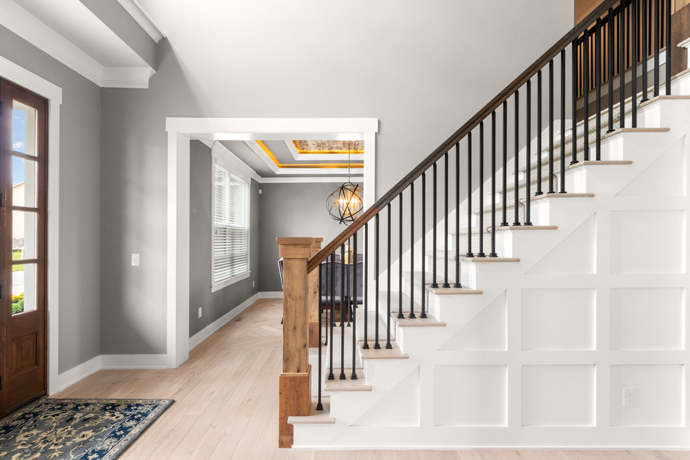 This is an example of a medium sized classic foyer in Columbus with grey walls, light hardwood flooring, a single front door, a dark wood front door and beige floors.