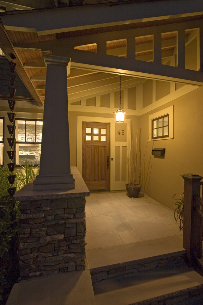 Aménagement d'une grande porte d'entrée craftsman avec un sol en ardoise, une porte simple et une porte en bois brun.