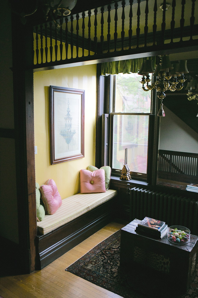 Bild på en liten vintage entré, med gula väggar och ljust trägolv