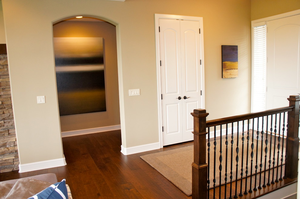 Foto de distribuidor clásico renovado con paredes beige, suelo de madera en tonos medios y puerta simple