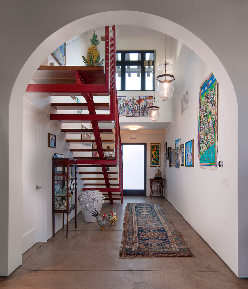 На фото: узкая прихожая среднего размера в средиземноморском стиле с белыми стенами, бетонным полом, одностворчатой входной дверью и стеклянной входной дверью с
