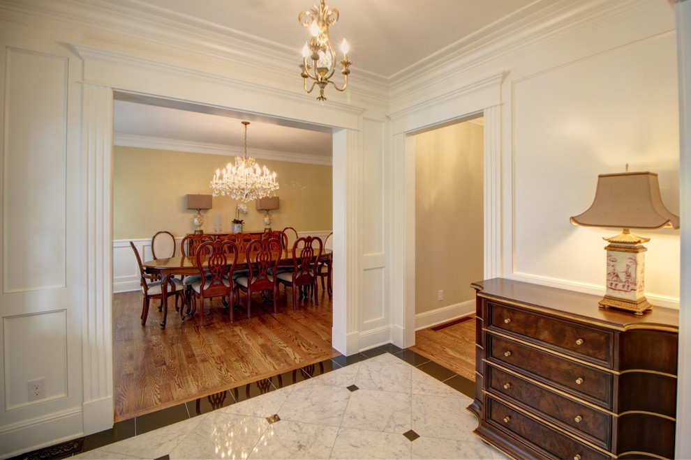 デンバーにある高級な広いトランジショナルスタイルのおしゃれな玄関ロビー (白い壁、テラゾーの床) の写真