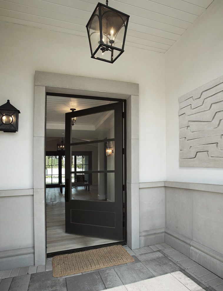 フェニックスにあるラグジュアリーな広いトランジショナルスタイルのおしゃれな玄関ラウンジ (黒いドア、黄色い壁、コンクリートの床、グレーの床、塗装板張りの天井、パネル壁) の写真