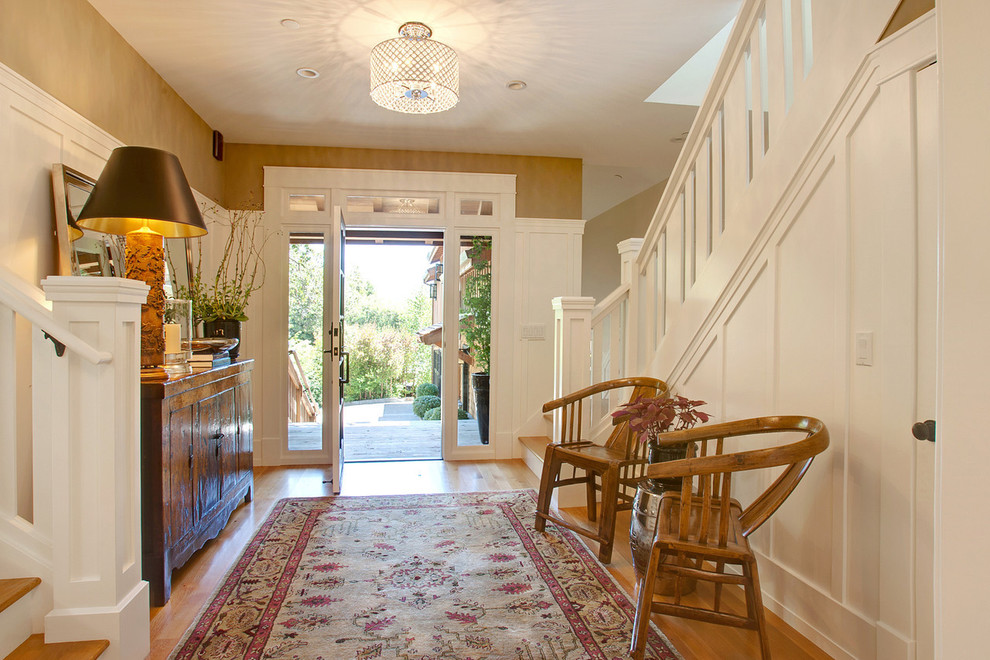 Example of a transitional medium tone wood floor entryway design in San Francisco with brown walls