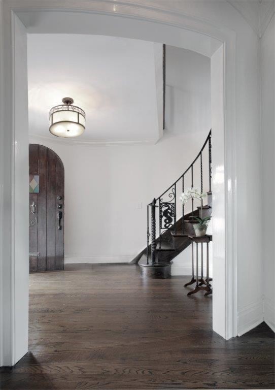 Großes Klassisches Foyer mit weißer Wandfarbe, dunklem Holzboden, Einzeltür und dunkler Holzhaustür in New York