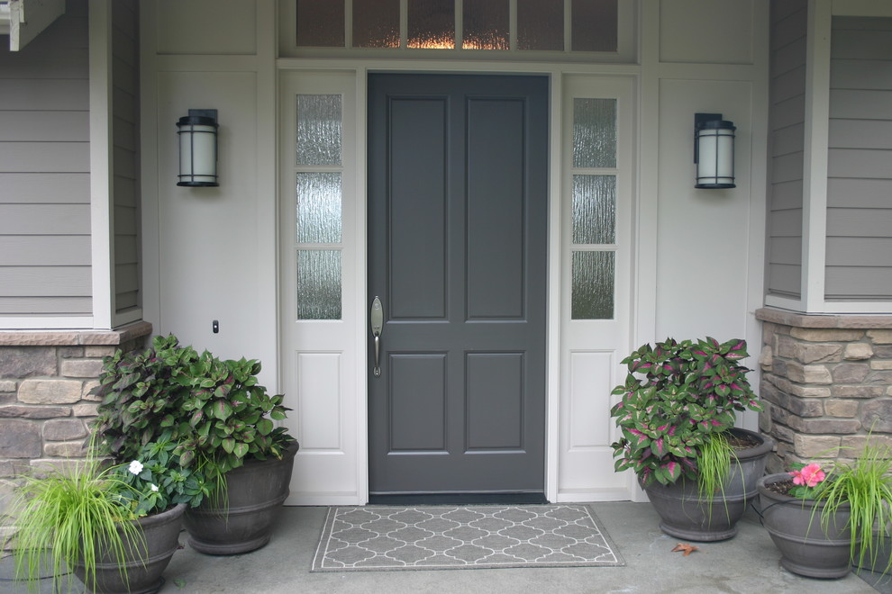 Cette image montre une porte d'entrée traditionnelle de taille moyenne avec une porte simple, une porte grise, un mur blanc, sol en béton ciré et un sol gris.