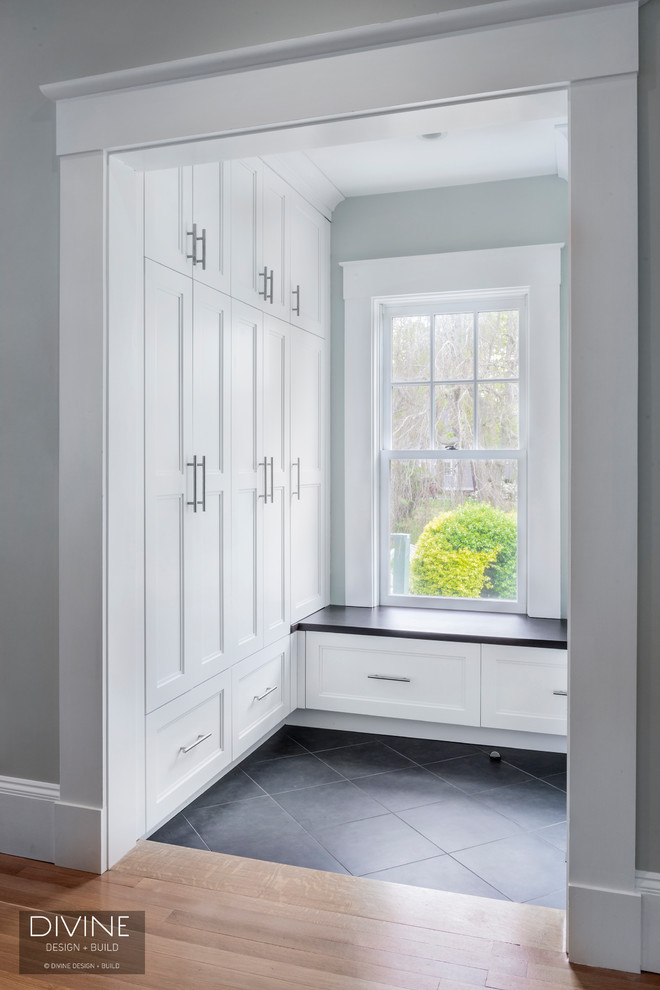 This is an example of a medium sized classic boot room in Boston with grey walls, slate flooring, a single front door, a black front door and black floors.