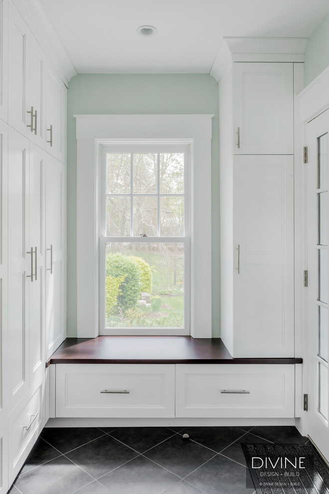На фото: тамбур среднего размера в стиле неоклассика (современная классика) с серыми стенами, светлым паркетным полом, одностворчатой входной дверью, черной входной дверью и бежевым полом с
