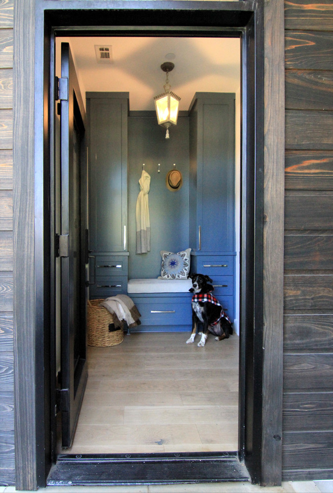 Idée de décoration pour une porte d'entrée tradition de taille moyenne avec un mur bleu, parquet clair, une porte simple et une porte noire.