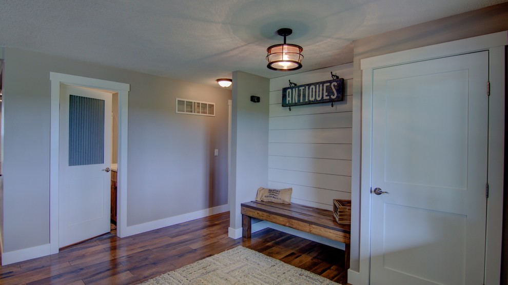 Ispirazione per un corridoio tradizionale di medie dimensioni con pareti beige, pavimento in legno massello medio, una porta singola e una porta bianca