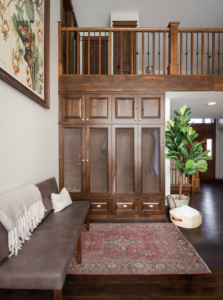 Example of a large transitional dark wood floor, brown floor and vaulted ceiling entryway design in Denver with white walls and a dark wood front door