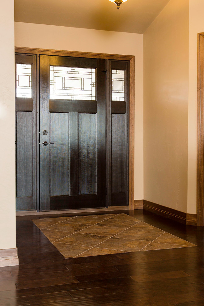 Immagine di una porta d'ingresso american style di medie dimensioni con pareti beige, pavimento in legno massello medio, una porta singola, una porta in legno scuro e pavimento marrone