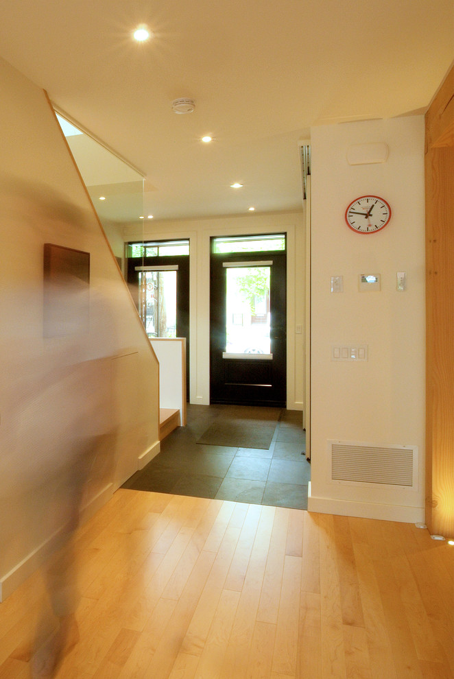 Modelo de hall actual de tamaño medio con paredes beige, suelo de madera clara, puerta simple y suelo beige