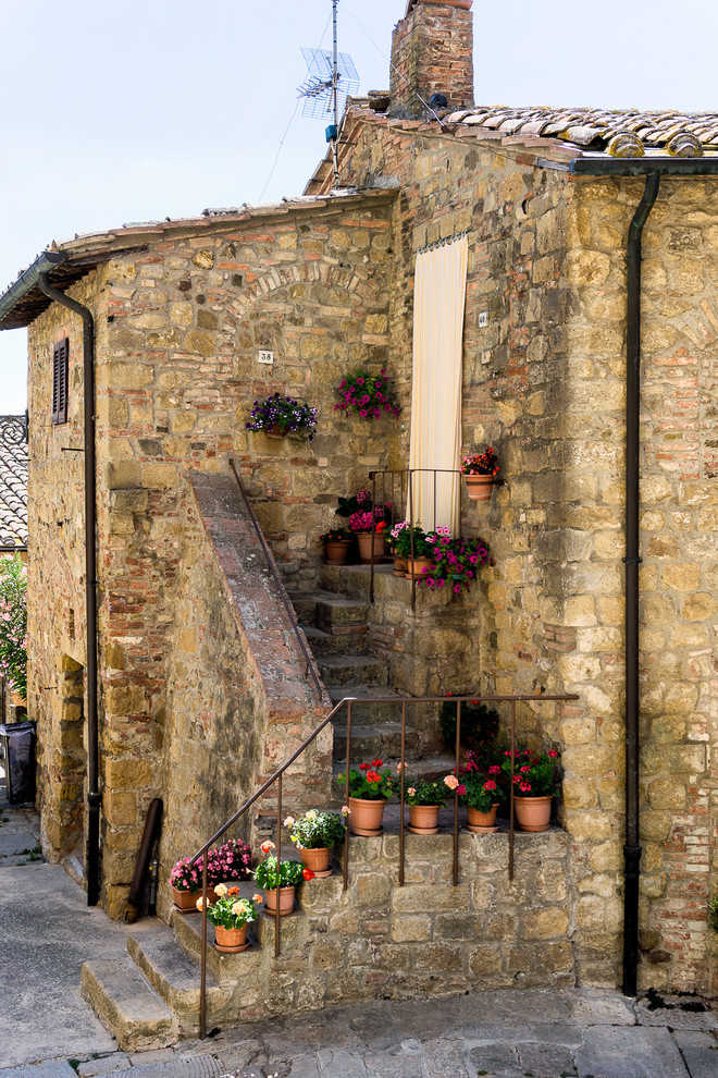 フィレンツェにあるカントリー風のおしゃれな玄関ドア (グレーの壁、グレーの床) の写真