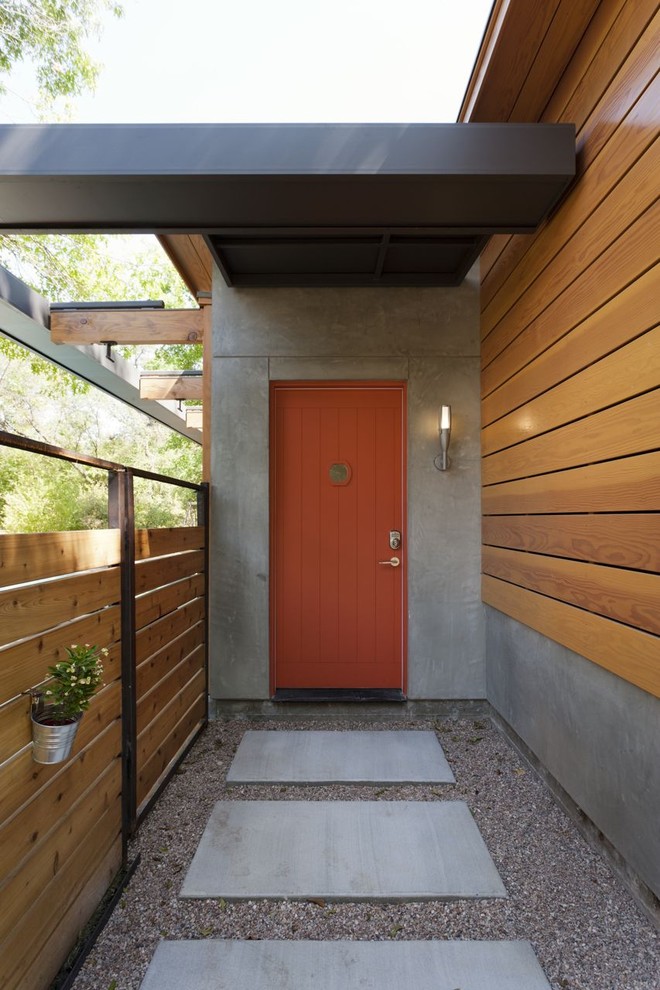 Modern inredning av en entré, med en orange dörr