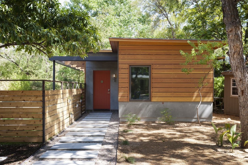 Photo of a contemporary entrance in Austin with an orange front door.
