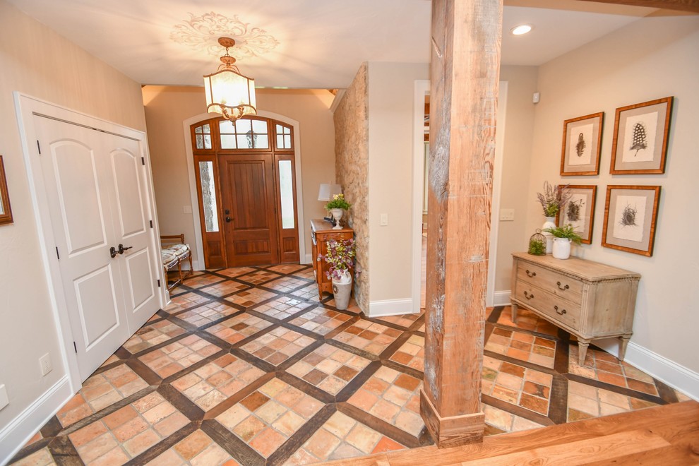 Entryway - mid-sized farmhouse travertine floor and multicolored floor entryway idea in Milwaukee with beige walls and a medium wood front door
