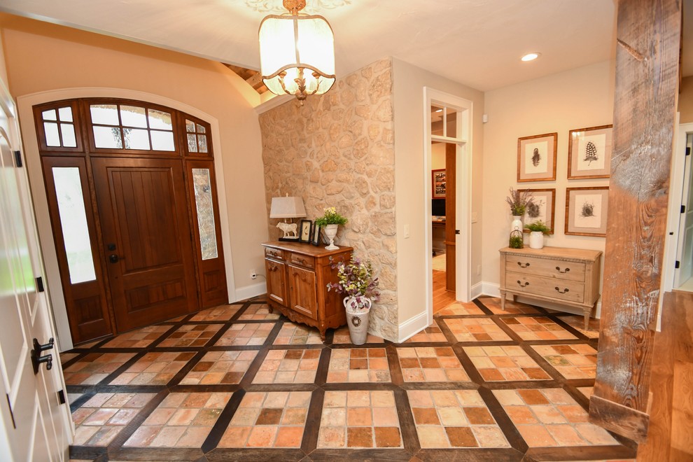 Inspiration for a mid-sized farmhouse travertine floor and multicolored floor entryway remodel in Milwaukee with beige walls and a medium wood front door