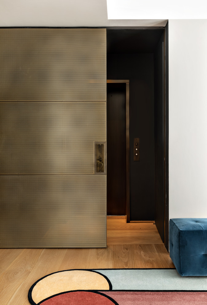 Foto de vestíbulo escandinavo de tamaño medio con paredes grises, suelo de madera clara, puerta corredera, puerta metalizada y suelo beige