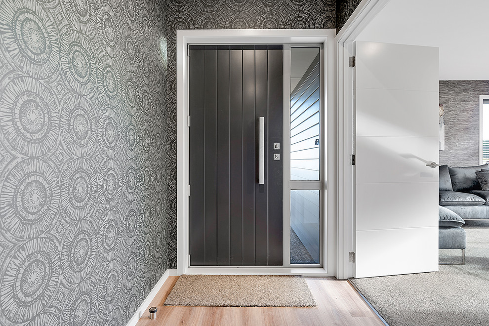 Idée de décoration pour une entrée design avec un couloir, un mur gris, parquet clair, une porte simple et une porte noire.