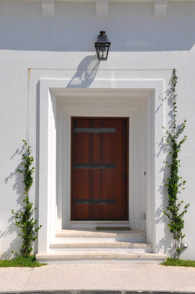 Idées déco pour une porte d'entrée exotique avec une porte simple et une porte en bois foncé.