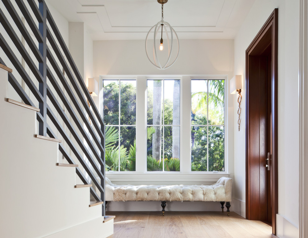 Inspiration for a large transitional light wood floor and beige floor entryway remodel in Miami with white walls and a medium wood front door