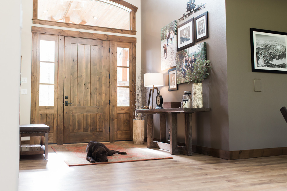 Large mountain style light wood floor and brown floor entryway photo in Seattle with beige walls and a medium wood front door