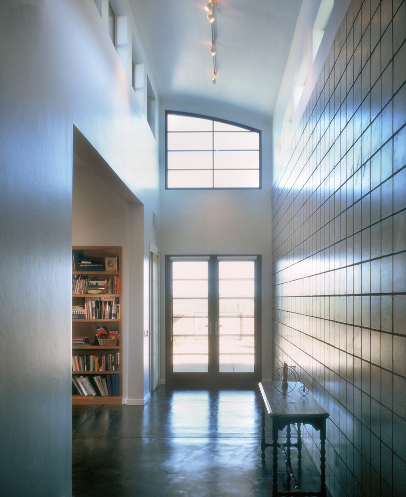 Entryway - mid-sized contemporary concrete floor entryway idea in Phoenix with white walls and a glass front door