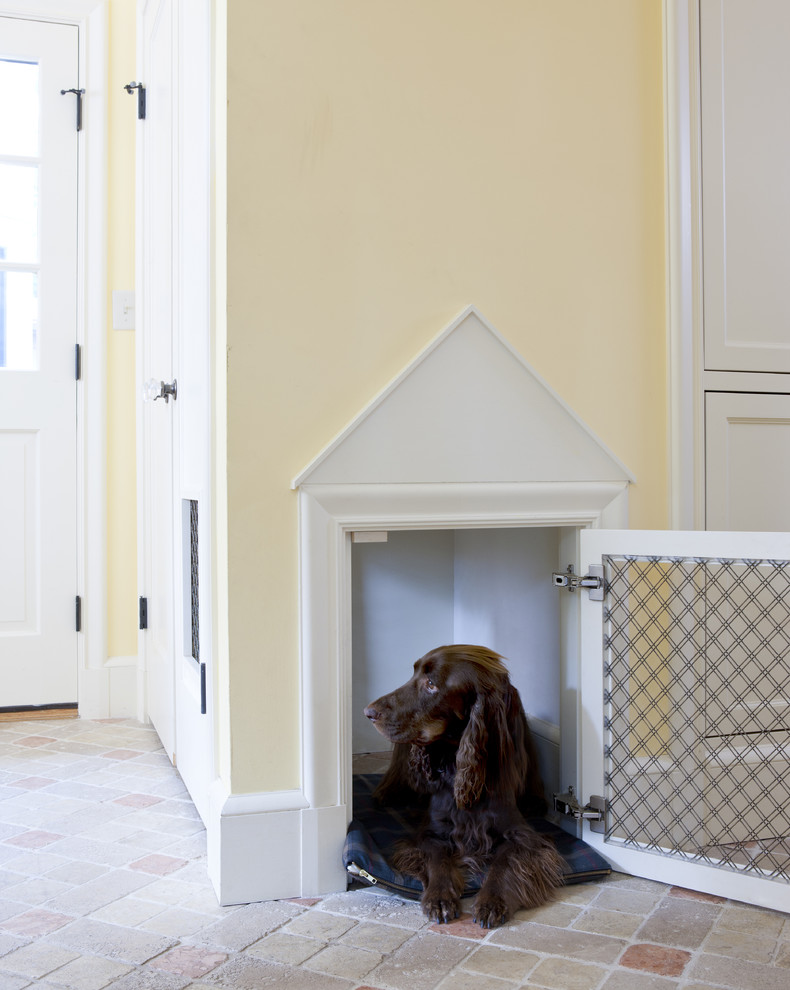 Elegant brick floor mudroom photo in Boston with yellow walls