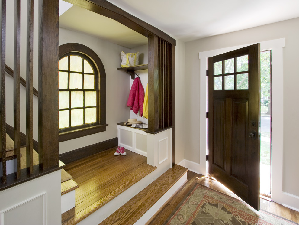 Ispirazione per una piccola porta d'ingresso american style con pareti grigie, pavimento in legno massello medio, una porta singola e una porta in legno bruno