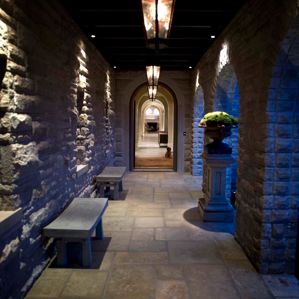 Cette image montre un grand vestibule traditionnel avec un sol en calcaire et une porte simple.