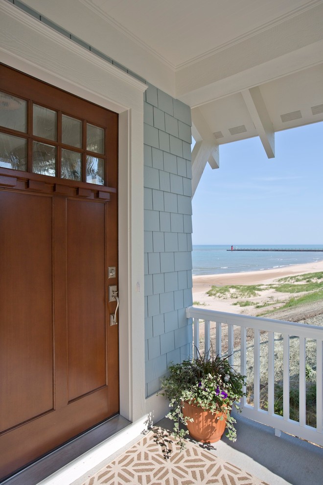 Idee per una grande porta d'ingresso stile marino con pareti blu, una porta singola e una porta in legno bruno