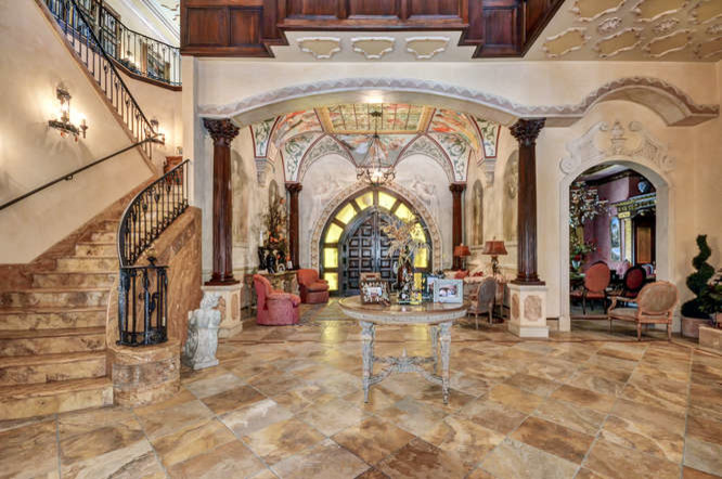 Geräumiges Mediterranes Foyer mit beiger Wandfarbe, Travertin, Doppeltür, dunkler Holzhaustür und gelbem Boden in Tampa