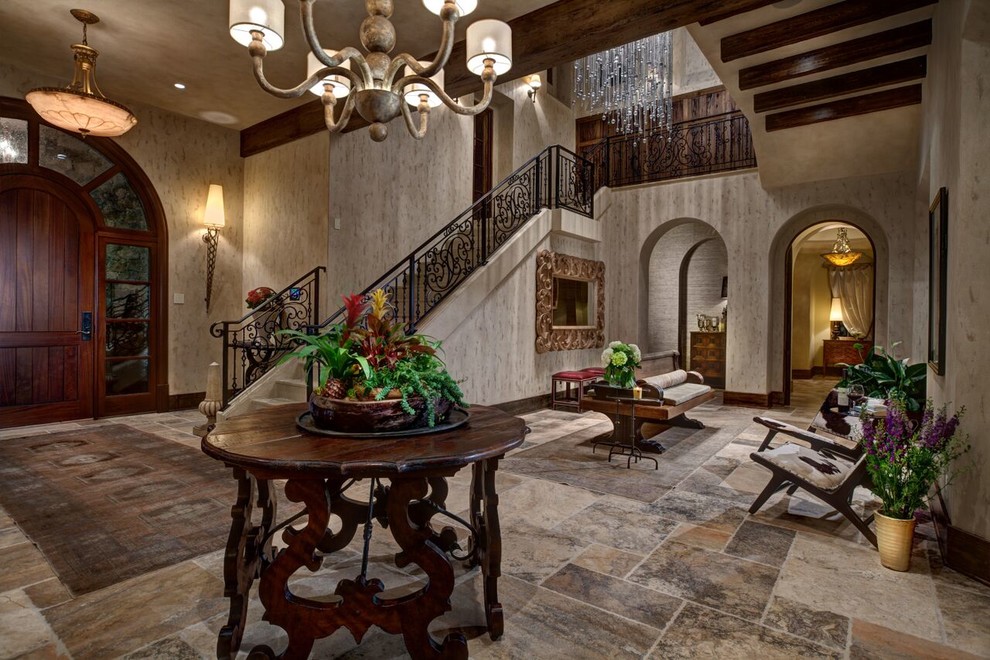 Example of a tuscan entryway design in Orlando with beige walls and a dark wood front door