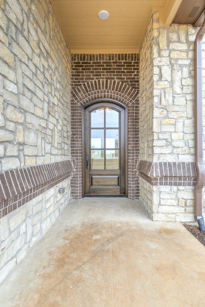 На фото: входная дверь в средиземноморском стиле с белыми стенами, одностворчатой входной дверью, входной дверью из темного дерева и коричневым полом