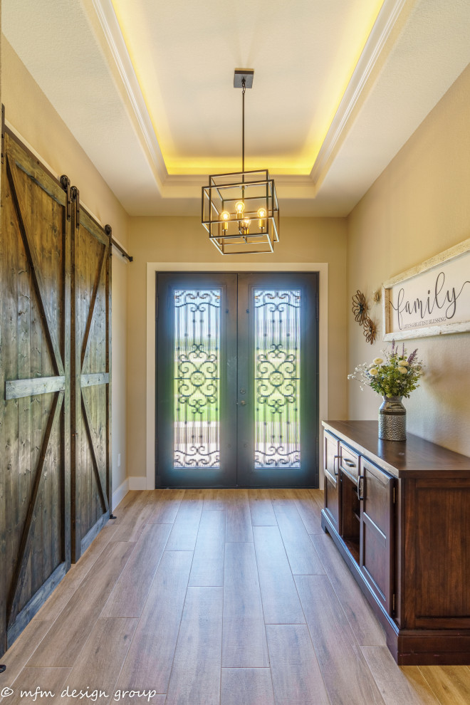Mittelgroßes Rustikales Foyer mit beiger Wandfarbe, hellem Holzboden, Doppeltür, schwarzer Haustür, braunem Boden und eingelassener Decke in Austin