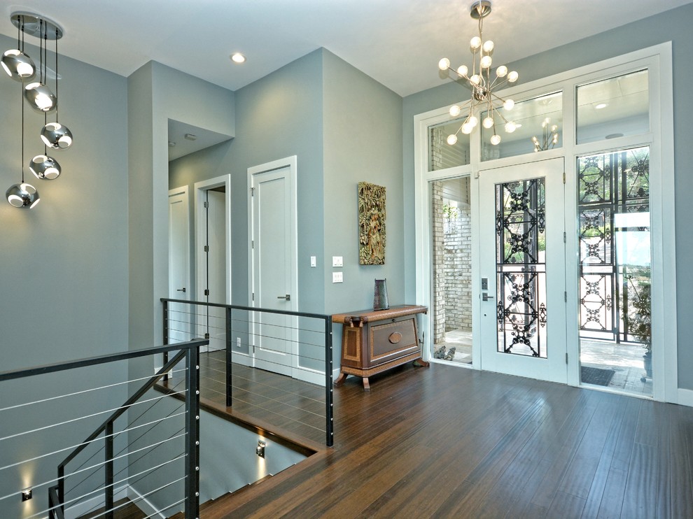 Réalisation d'un hall d'entrée design de taille moyenne avec un mur bleu, parquet foncé, une porte simple, une porte blanche et un sol marron.