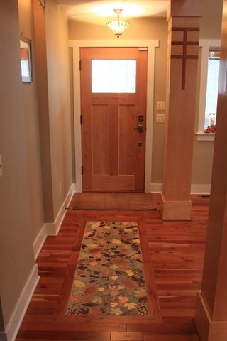This is an example of a contemporary foyer in Grand Rapids with beige walls, medium hardwood flooring, a single front door and a light wood front door.