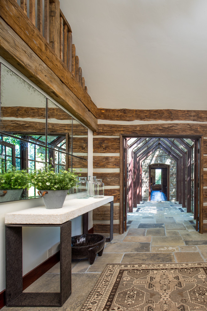 Aménagement d'une entrée contemporaine de taille moyenne avec un couloir, un mur marron, une porte simple, une porte en bois foncé et un sol en travertin.