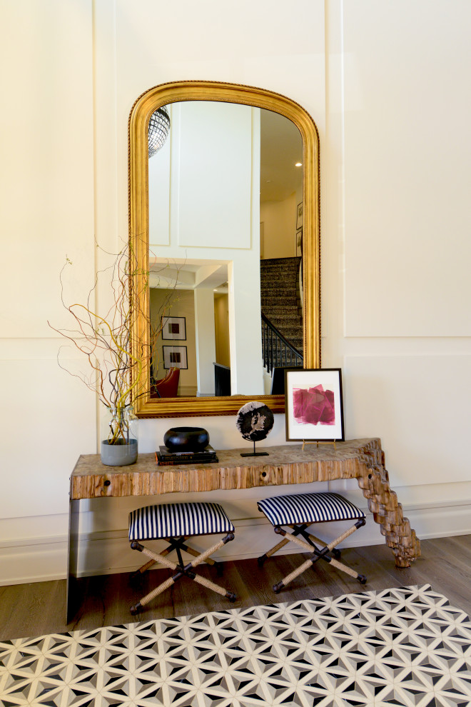 Cette photo montre un grand hall d'entrée moderne avec un mur beige, une porte double, une porte en bois foncé, un sol marron et un plafond à caissons.